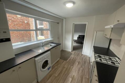 Bright galley kitchen with a long countertop, i...