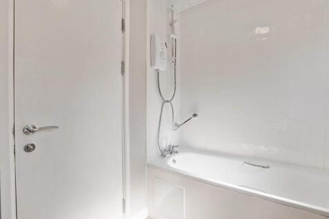 Bright, modern bathroom with a clean white bath...