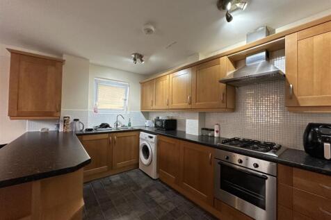 Well-equipped galley kitchen with wooden cabine...