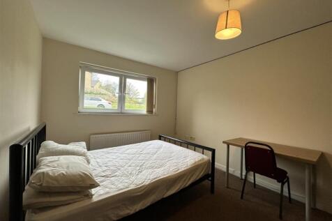 Bright, simply furnished bedroom with a double ...