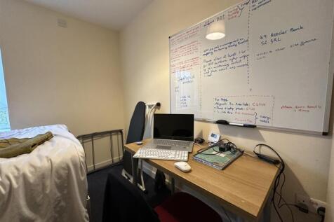 Compact bedroom with a tidy study area featurin...