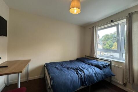 Bright, simply furnished bedroom with a double ...