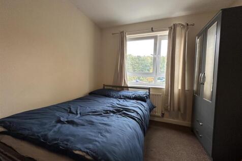 Bright, simply furnished bedroom with a double-...