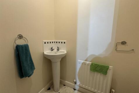 Compact corner washbasin in a neat cloakroom wi...