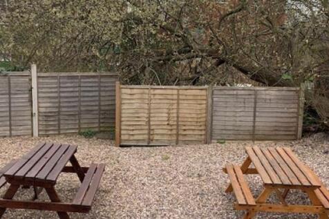 Private gravelled garden with two wooden picnic...