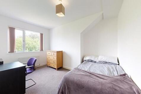 Bright, simply furnished bedroom with a double ...