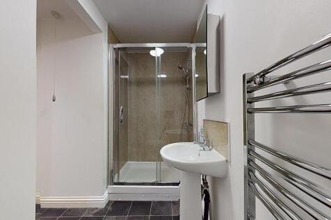 Modern bathroom with a glass-enclosed shower, w...