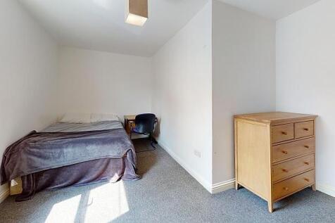 Bright, simply furnished bedroom with a double ...
