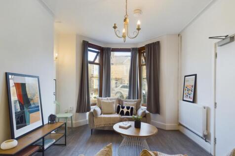 A stylish and spacious living room filled with ...