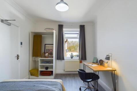 A bright and inviting double bedroom with a des...