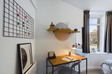 A bright and tidy double bedroom featuring a st...