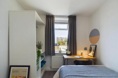 A bright and stylish double bedroom featuring a...