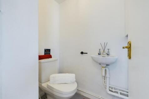A clean and tidy single toilet with modern fixt...