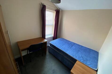 A bright and tidy single bedroom featuring a de...