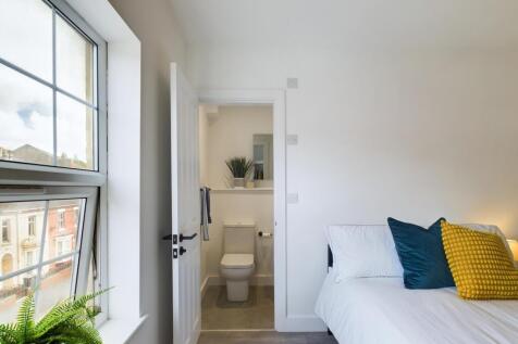 A bright and inviting double bedroom with a wel...