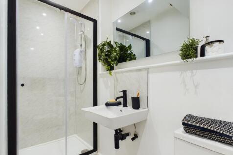 A modern and immaculate bathroom featuring a st...
