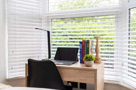 Bright bay-window workspace with a compact wood...