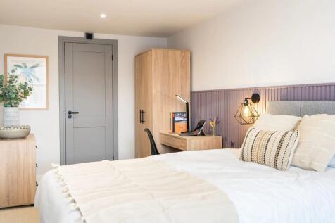 Bright, modern master bedroom with a comfortabl...