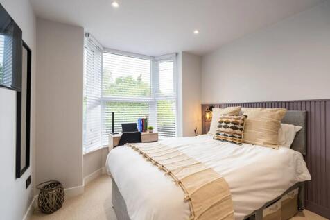 Bright, neatly styled double bedroom with a lar...