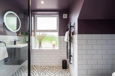 Stylish bathroom with white subway tiles, patte...