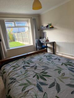Bright, tidy bedroom with a large window overlo...