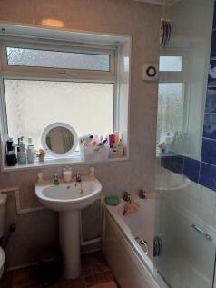 Bright and tidy bathroom with a pedestal sink, ...