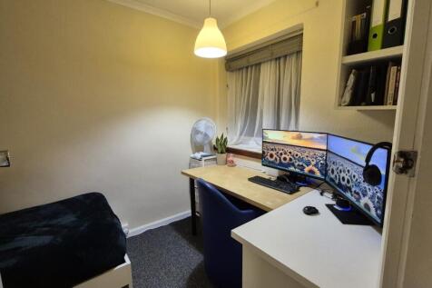 Cozy single bedroom with a tidy study setup fea...