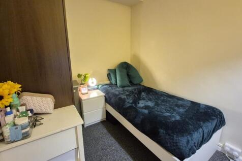 Cozy single bedroom with a neatly made bed, bed...