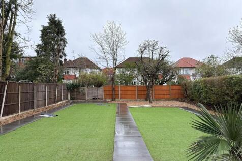 Well-kept rear garden with a central paved path...