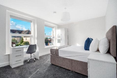 Bright, modern double bedroom with large sash w...