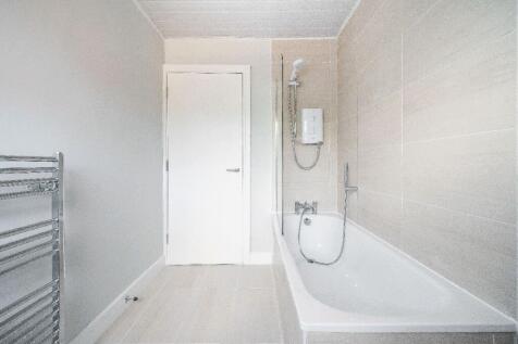 Bright, modern bathroom with a full-size bathtu...