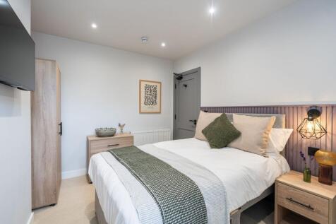 A modern and cozy double bedroom featuring a co...