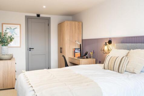 A bright and well-decorated bedroom featuring a...