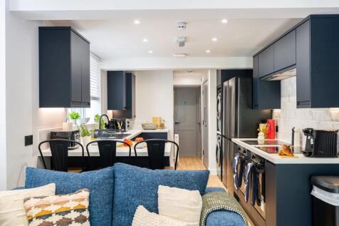 Modern, spacious kitchen with sleek dark cabine...