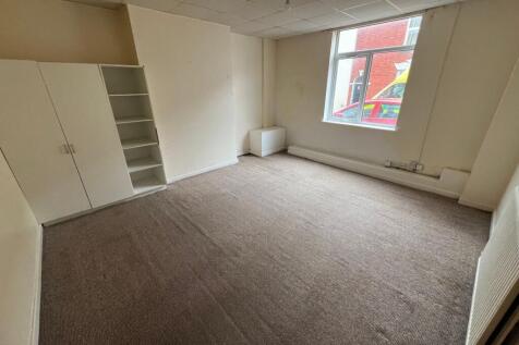 A simple, unfurnished single bedroom featuring ...
