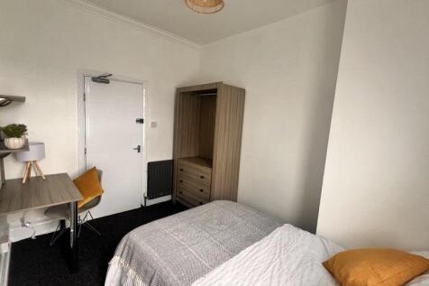 A cozy single bedroom featuring a comfortable b...