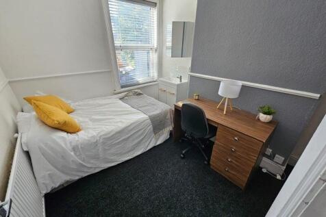 A cozy bedroom featuring a single bed with brig...