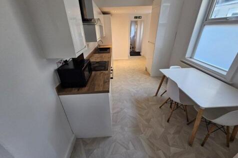 Bright and modern kitchen featuring sleek white...