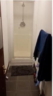 Compact bathroom featuring a shower space with ...