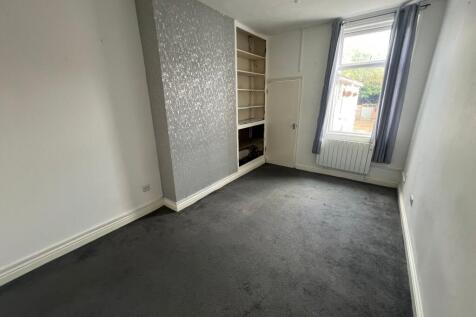 A tidy single bedroom featuring a large window ...