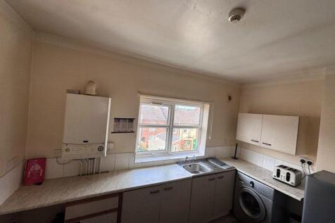 A practical kitchen featuring a large window pr...