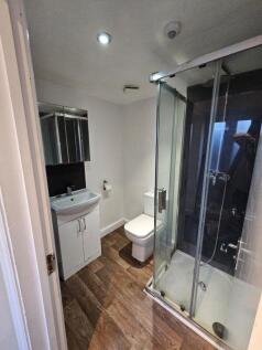 A modern bathroom featuring a glass-enclosed sh...