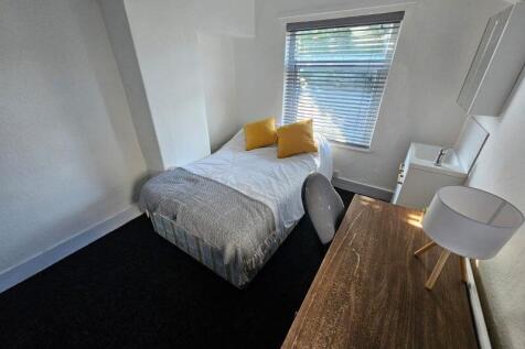 Cozy single bedroom featuring a comfortable bed...