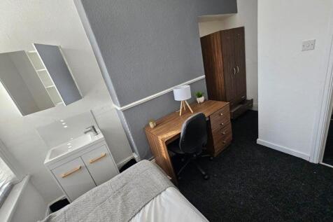 A cozy single bedroom featuring a comfortable b...