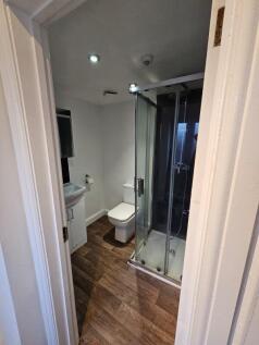 Modern bathroom featuring a glass-enclosed show...