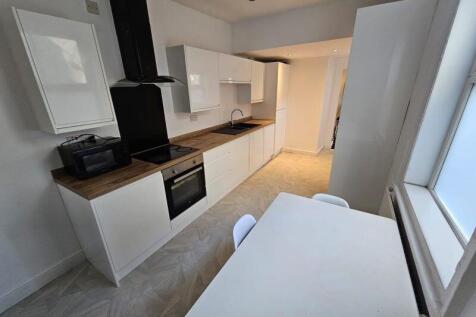 Bright and modern kitchen featuring sleek white...