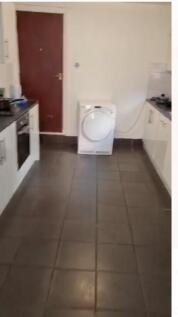 A tidy kitchen featuring modern white cabinetry...