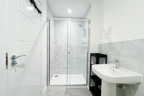Bright, modern bathroom with a glass-enclosed w...