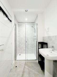 Bright, modern bathroom with a tiled walk-in sh...
