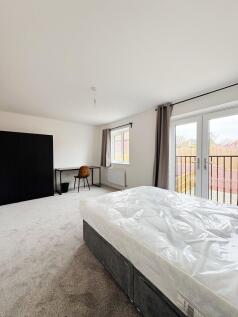 Bright, modern bedroom with large floor-to-ceil...